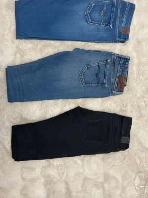 Tre par jeans i olika färger - Säljer tre par jeans i olika färger: ett par ljusblå, ett par mellanblå och ett par svarta. Alla har klassisk femficksdesign och raka ben. Perfekta för dig som gillar stilrena och enkla jeans. Märkena syns på bakfickan men är svåra att tyda på bild. storlekar är W28 L 32 svart, och W 29 L30 mellanblå W28 L29 på ljusblå, köp alla 3 på samma gång perfekt för reselling!