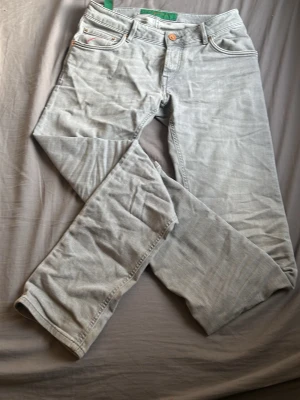 Handpicked jeans  - Ett fint grått par handpicked jeans med röd mocka där bak och en röd design där fram dem är i storlek 31/32 påse finns till , nypris 2999