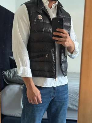 Moncler Gui Väst - Riktigt schysst gui väst i storlek 2-S/M. Självfallet äkta! Passar dig mellan 170-180cm. Nypris ligger på ca 9299kr. Västen har inga defekter alls! Perfekt till sommaren som extra lager! Bara att kontakta vid funderingar!🌟
