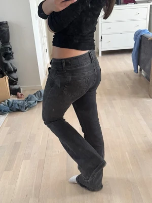 Svarta bootcut jeans med stretch - Säljer ett par svarta bootcut jeans med snygg passform och stretchigt material. Jeansen har klassiska fem fickor och normalhög midja. Perfekta för dig som vill ha en tidlös look med lite utsvängda ben.