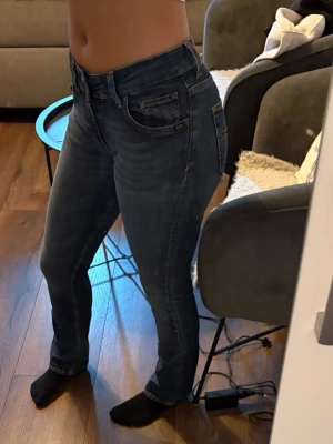 Mörkblå slim fit jeans med stretch - Snygga mörkblå slim fit jeans med stretch och fem fickor. Jeansen har  sömmar och en fin passform som sitter tajt över höften och låren.