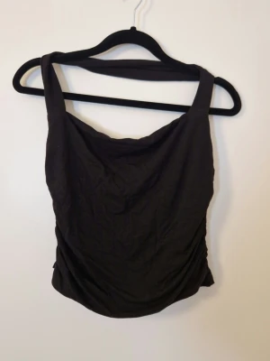 Svart halterneck från Gina - Använd en gång sen tvättad och har legat längst inne i garderoben sen dess. Stretchigt mjukt material. Dubbelt tyg vid bysten.
