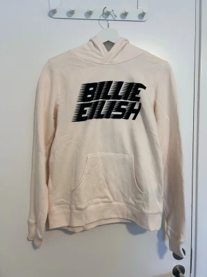 Billie Eilish hoodie - Snygg ljusbeige hoodie med svart Billie Eilish-tryck på bröstet. Köpt från H&M
