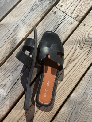 Svarta Hermès likande slip-in sandaler - Fint skick o knappt använda! Lite små i storlek, har vanligtvis 38/38,5