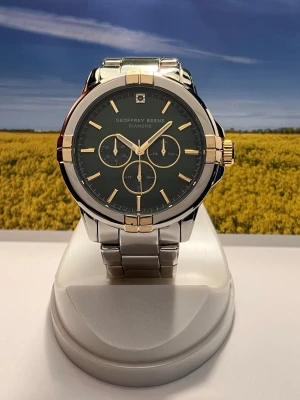 Geoffrey Beene Diamond  herrklocka i stål - Stilren herrklocka från Geoffrey Beene Diamond med svart urtavla, guldfärgade detaljer och robust armband i rostfritt stål. Klockan har tre subdials och markerade index, samt guldfärgad krona och bezel. Perfekt accessoar för en modern look. Levereras i original box, säljes i befintligt skick enligt bilderna! 