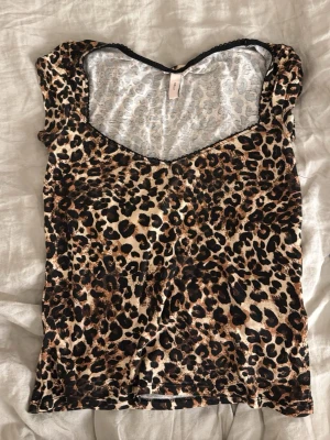 Leopardmönstrad topp från Nelly - Snygg leopardmönstrad topp från Nelly med v-ringning och svarta spetsdetaljer vid halsen. Superfin men säljer då jag inte använder den längre💓💓 