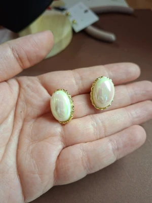Guldpläterade örhängen med pärlemo - Snygga örhängen med oval form och pärlemo-liknande yta, omgivna av en tunn guldfärgad ram. Perfekta för dig som gillar klassiska accessoarer med vintagekänsla. Ger en elegant touch till din stil.