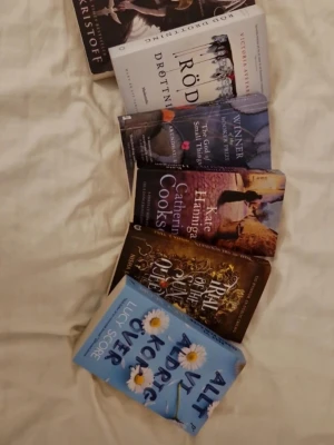 Bokpaket skönlitteratur 6 titlar - Säljer ett bokpaket med sex skönlitterära böcker i pocket- och inbunden form. Bland titlarna finns 'Röd drottning', 'Trail of the Sun Queen', 'Alt vi aldrig sa', samt böcker av Jay Kristoff, Catherine Cookson och Arundhati Roy. Omslagen är färgglada med motiv och text. Kan också säljas separat!