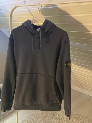 Svart hoodie från Stone Island - Säljer en Stone Island hoodie i mörkblå färg.  Hoodien är i bra skick med normalt bruksslitage men inga större skador, hål eller fläckar. Den är väldigt bekväm och har den klassiska Stone Island-stilen med premium känsla och snygg passform.  Storlek är XXL, men den sitter mer som en vanlig L i passformen.  Personen på bilden är 190 cm lång, väger ca 80 kg och bär vanligtvis storlek L – vilket visar hur hoodien sitter i praktiken.  Pris: (du kan fylla i pris här) Storlek: XXL (passar som L)
