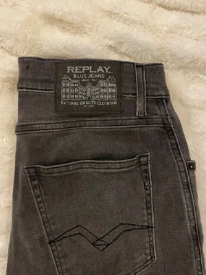 Grå jeans från Replay - Snygga grå jeans sandot relaxed tapered från Replay . Jeansen har en cool tvättad look och detaljerad bakficka med broderad söm. Tillverkade i slitstarkt denimtyg som ger en skön passform och stilren vibe. Om ni har några frågar det är bara att ställa dem och vi kan diskutera priset.