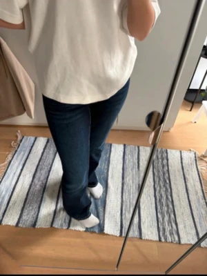 Mörkblå bootcut jeans - Snygga mörkblå bootcut jeans med klassisk femficksdesign och normalhög midja. Jeansen har en smal passform upptill och lätt utsvängda ben. Jättefina fickor på rumpan.