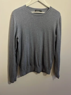 Ljusblå tröja från Dressmann, Supima bomull - En stilren ljusblå tröja från Dressmann i mjuk Supima bomull. Tröjan har rund halsringning, långa ärmar och en enkel, klassisk design som passar till det mesta. Perfekt för dig som gillar en clean och bekväm look.