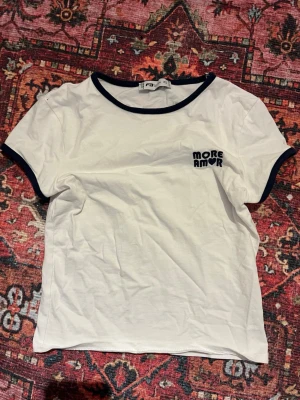 Vit t-shirt med blå detaljer - Vit t-shirt med mörkblå kant vid hals och ärmslut