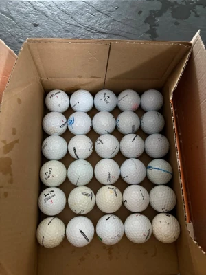 Låda med blandade golfbollar - Säljer en låda med 30 st vita golfbollar från olika märken som Titleist, Callaway, Nike och TaylorMade. Bollarna är i skick som på bild men har otroligt många slag kvar, perfekta för dig som vill fylla på golfbagen med extra bollar inför säsongen! Bara höra av sig om man skulle vilja lägga till fler!