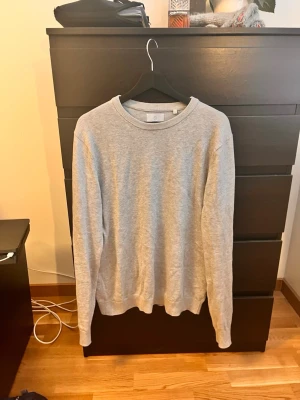Ljusgrå sweatshirt - En enkel och stilren ljusgrå sweatshirt med rund halsringning och ribbade muddar. Perfekt för en avslappnad look och lätt att matcha med det mesta. Tillverkad i mjukt material för extra komfort.