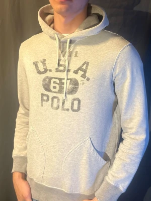 Ralph Lauren Hoodie - Snygg grå Hoodie från Ralph Lauren. Modellen är 190cm och väger 80kg. Skriv om du har frågor 🥰