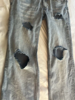 Ljusblå slitna low bootcut jeans från cheap monday - (Kostade 400 från början) Säljer ett par ljusblå low bootcut jeans från cheapmonday med flera stora slitningar och hål på benen som jag gjort själv. Älskar dem här jeansen och ända anledningen till att jag säljer dem är att dem är lite stora i midjan och för långa. Använt dem max 3 gånger.