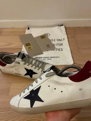 Golden Goose skor - Ett par sjukt snygga Golden Goose i en unik men sjukt snygg färg!🌟 Vinröd häl och mörkblå stjärna! Storlek 43. Dustbag fås med som syns i bilden! Kvitto och äkthetsbevis finns!😊 Skick 9/10, grymt skick!