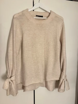 Beige stickad tröja - Från Zara med rosetter på ärmarna. Så söt!