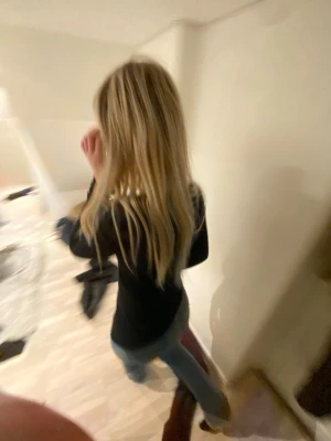 Blå raka jeans med hög midja - Säljer ett par klassiska blå jeans med rak passform och hög midja. Jeansen har en tidlös look och är perfekta att matcha med olika stilar. Materialet ser ut att vara denim och färgen är en mellanblå tvätt.