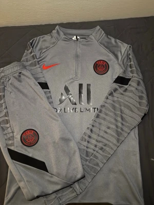 Grå PSG träningsset från Nike - Grå PSG nike fotbollstracksuit, helt ny. Passar S och M men då är de mer slim fit. Kom dm om du har frågor eller vill ha mer bilder, skicka gärna bud också!