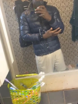 Mörkblå dunjacka med huva - Snygg mörkblå dunjacka med huva och dragkedja framtill. Jackan har quiltad design och en patch på vänster ärm. Perfekt för kalla vinterdagar och ger en sportig look.