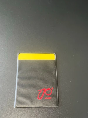 JO Sport domarkortsfodral - Säljer ett svart domarkortsfodral från JO Sport med plats för både gult och rött kort. Perfekt för dig som dömer fotboll eller andra sporter och vill ha koll på korten.