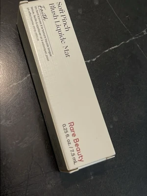Rare Beauty Soft Pinch Matte Liquid Blush - Säljer en Soft Pinch Matte Liquid Blush från Rare Beauty i färgen 'Faith'. Flytande rouge med matt finish, kommer i en stilren beige kartong. Innehåller 7,5 ml och ger en naturlig look med intensiv färg.