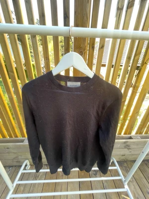 Svart longsleeve/sweatshirt  - En stilren svart tröja från Sandö. Tröjan är tunnstickad och passar till allt. Enkel design utan tryck eller mönster, vilket gör den lätt att matcha med olika outfits.
