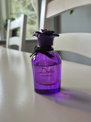 Dolce & Gabbana Violet - 30 ml från början, se bilder på hur mycket som är kvar. Förvarats svalt & mörkt.  Doften beskrivs som följande: Topp - Doften öppnar med den förtjusande svarta vinbärsknoppen som kombineras med glittrande, mandarin från Madagaskar och den mjuka, blommiga fräschören av cyklamenackord.  Hjärta - I hjärtat av Dolce Violet Eau de Toilette kombineras de förtrollande accenterna av viol med de saftiga noterna av björnbär och soldränkta päron.  Bas - Den sensuella och krämiga basen omsluter det kraftful