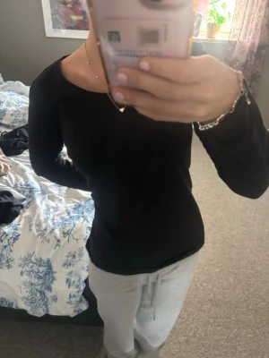Svart långärmad topp från Denim - En enkel och stilren svart långärmad topp från Denim. Modellen har rund halsringning och är gjord i mjuk bomull som sitter bekvämt mot kroppen. Perfekt basplagg att matcha med allt i garderoben.