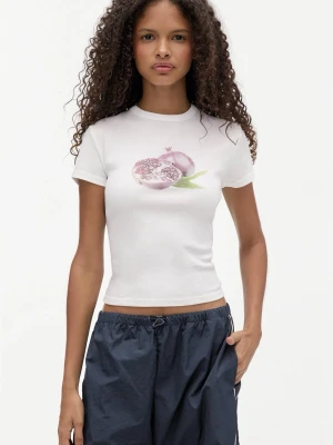 Vit t-shirt med granatäppletryck - Vit, tight t-shirt med ett tryck av ett granatäpple på bröstet. T-shirten har korta ärmar och rund halsringning. Perfekt för en chill och trendig look. Säljs inte längre.