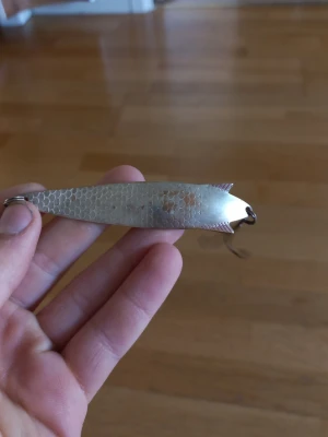 Fiskedrag Toby i silverfärg - Säljer ett klassiskt fiskedrag av modellen Toby från ABU Garcia. Draget är silverfärgat med fiskfjällsmönster och har en trekrok. Skeddrag tillverkat i metall och väger 18 g. Perfekt för fiskeentusiasten som vill ha ett pålitligt drag i lådan.