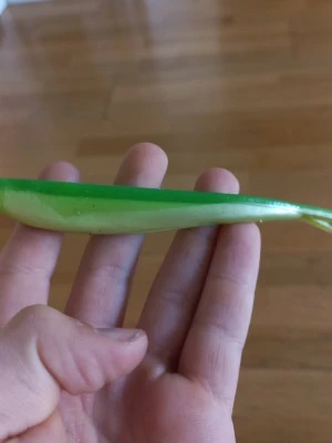 Grön jigg för fiske - En jigg  grönt och ljusgult, perfekt som bete vid fiske. Fisken har en smal kropp och kluven stjärt, tillverkad i mjukt plastmaterial. Passar till olika typer av sportfiske och är enkel att fästa på kroken.