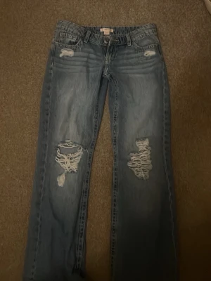 Gina tricot 14+ jeans  - Säljer ett par ljusblå baggy jeans med slitningar och hål på båda benen framtill. Jeansen har klassisk femficksdesign och detaljerade bakfickor. Perfekta för en avslappnad och trendig look. Ordinar pris är 399kr säljer för 250kr (pris kan diskuteras)💕