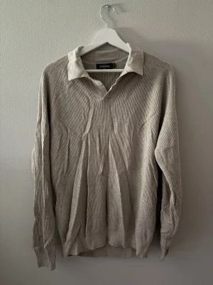 Beige Piké tröja från Dressman - En riktigt snygg och stilig Piké Tröja från dressman! Otroligt skön och snygg i dagens stil! Nypris: 1200kr Den högra ärmen är tyvärr uppriven, jag kan återgärda det med att sy igen den eller om du själv vill! 