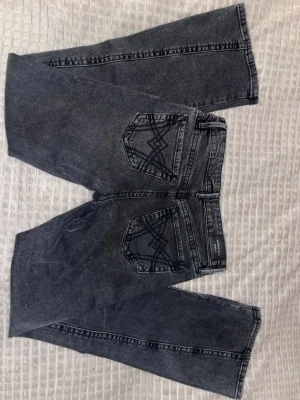 Svarta bootcut jeans med broderade fickor - Snygga svarta bootcut jeans från Gina tricot med broderade detaljer på bakfickorna samt streckade på framsida ben. Jeansen har klassisk femficksdesign, normal passform i stl 34. Livhöjd är low/mid (endast använda 1 gång)