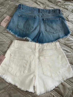 Två jeans shorts från Nelly.com - Säljer två par shorts från Nelly.com i storlek 34. Blåa och vita. Styck pris är 499kr för ett par. Säljer båda för 550kr 