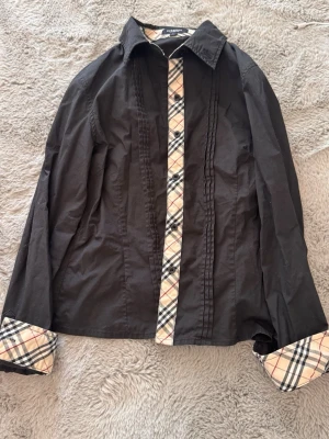 Burberry skjorta Xs - Säljer en burberry skjorta som är i Stl L för barn som motsvarar ca xs/xxs. Den är väldigt snygg och har inga hål eller defekter. Hör av er vid funderingar