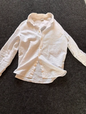 Vit linneskjorta från Lindex - perfekt för sommaren  - Klassisk vit skjorta i linne från Lindex med krage och knäppning framtill. Skjortan har lång ärm och en avslappnad passform, perfekt för en stilren look. Sval och skön att bära under varmare dagar. Har endast använt denna ett par gånger och har därför inga tecken på användning. Perfekt att använda med ett par beige eller blåa linnebyxor👌Tveka inte på att höra av dig om du har fler frågor eller vill ha fler bilder✅ Prisförslag är mer än välkommet👍