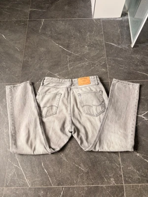 Grå raka jeans från Jack and Jones - Ett par grå jeans från Jack and Jones. Storlek 30/30. Inga defekter. Modell: Loose/Chris