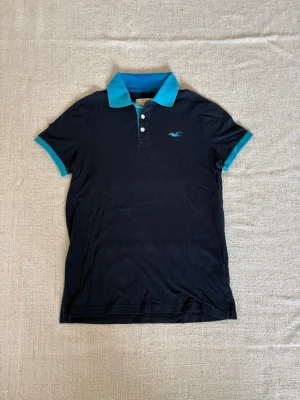 Hollister piké  - Perfekta lösningen på sommarens klädes problem. En piké i fint begagnat skick utan några konstigheter och som har mycket kvar att ge. Dessutom med ett pris på en femtedel av nypriset. Tveka inte på att slå till! (Postar inom 24h)