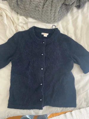 Marinblå kofta - Super söt mörkblå stickad kofta med korta ärmar från Gina! Knappt använd och säljer då den aldrig andvänds. Från Gina Young i 146/152 men passar xxs skulle jag säga. Pris kan absolut diskuteras och skriv vid frågor!❤️