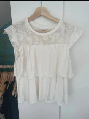 Vit topp med spets från Kappahl - Söt beige topp från Kappahl. Är i bra skick och använd fåtal gånger.