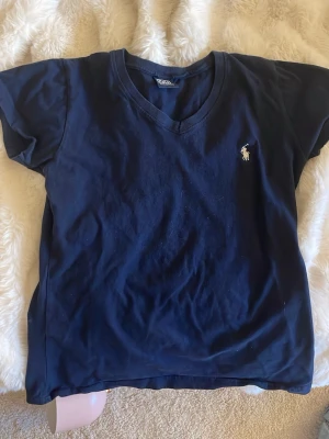 Ralth Lauren T-shirt  - Jag säljer en marinblå Ralth Lauren T-shirt i storlek M. Köptes i somras men oandvänd!🤍😽 (säljer en likadan i vit)