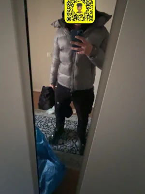 Grå pufferjacka från NVLTY - Snygg grå pufferjacka från NVLTY med hög krage och avtagbar huva. Jackan har två dragkedjeförsedda fickor på sidorna och en patch på ärmen. Perfekt för kalla dagar och riktigt skön att bära. Klassisk boxig passform och quiltad design.