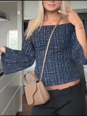 Blå offshoulder topp med vida ärmar - Trendig blå offshoulder topp med rutigt mönster och vida, långa ärmar. Toppen är croppad och har en smockad passform som ger en snygg siluett. Perfekt för dig som vill ha en cool och avslappnad stil.