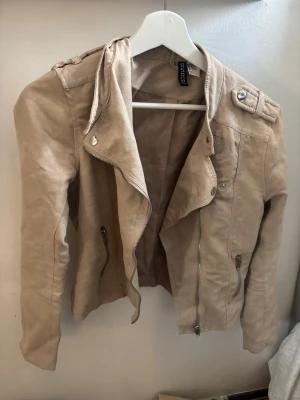 Beige vårjacka H&M - Beige vårjacka från divided H&M! Storlek 38 men sitter ändå ok på mig som brukar ha XS/S. Fick den begagnad så den har väll några år på nacken skulle jag gissa. Inga defekter alls, väldigt bra skick. Jag har aldrig använt den men jag kan inte svara på hur mycket den är använd innan mig. Ingen aning om vad dessa brukar kosta men jag sätter priset på 150kr så kan ni bara skriva vad ni själva skulle vilja betala! Obs! Endast köp via Plick. Hör gärna av er vid frågor eller likande🩷