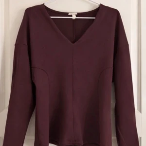 Vinröd V-ringad tröja från HM storlek S - Säljer en stilren vinröd tröja med V-ringning och långa ärmar. Tröjan har en enkel, rak passform och är tillverkad i ett mjukt material som känns skönt mot huden. Användt 1 gång. 