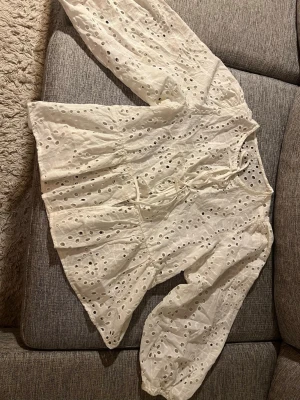 Vit broderad blus med puffärm - Söt vit blus i bomull med broderade hålmönster och puffiga långärmar. Blusen har knytband framtill och en luftig, avslappnad passform. Använd en gång!💕
